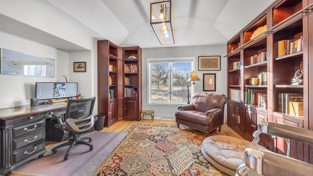 office area featuring a baseboard radiator, vaulted ceiling, and light hardwood / wood-style flooring