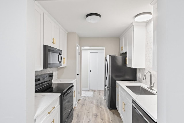 kitchen with sink, white cabinetry, tasteful backsplash, and black appliances