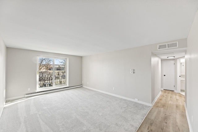 spare room with light wood-type flooring and a baseboard radiator