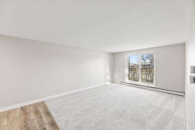 spare room with light wood-type flooring and a baseboard radiator