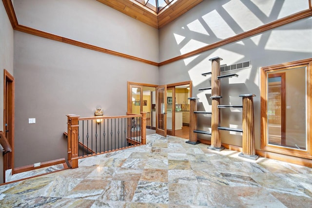 hall featuring a skylight and high vaulted ceiling