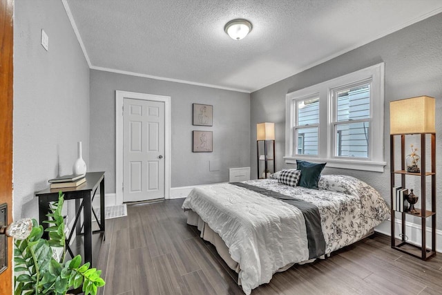 bedroom with a textured ceiling, crown molding, and hardwood / wood-style floors