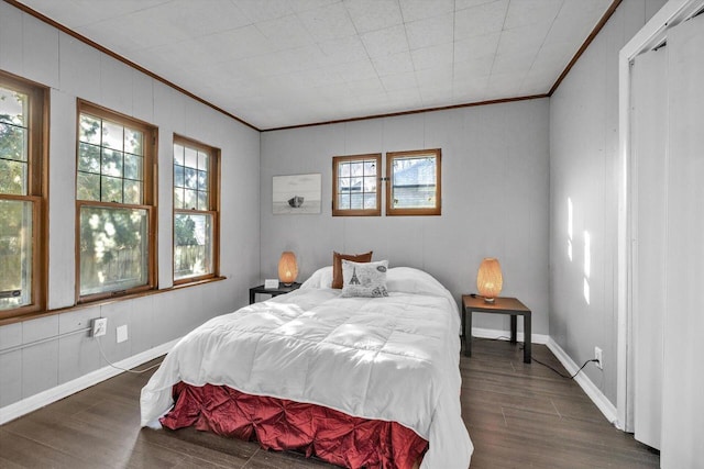 bedroom with ornamental molding and dark wood-type flooring