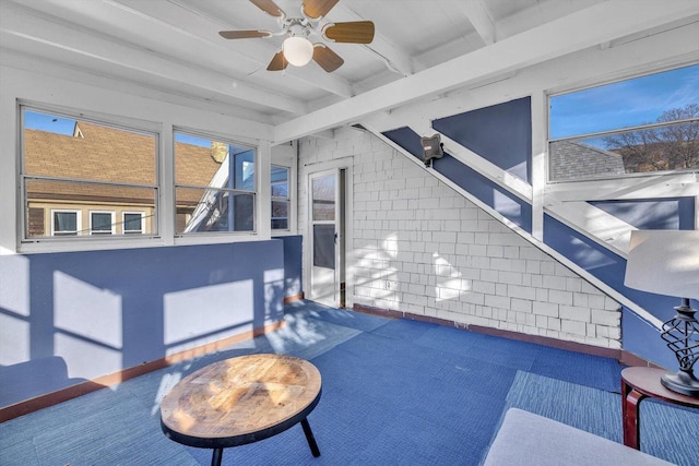 unfurnished sunroom with beam ceiling and ceiling fan