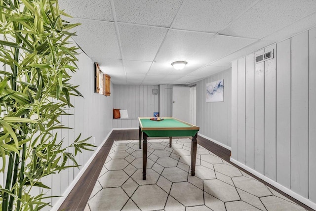 recreation room featuring a paneled ceiling and hardwood / wood-style floors