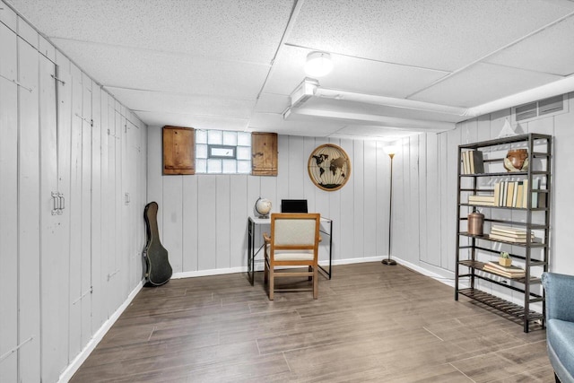 living area featuring wood-type flooring and wood walls