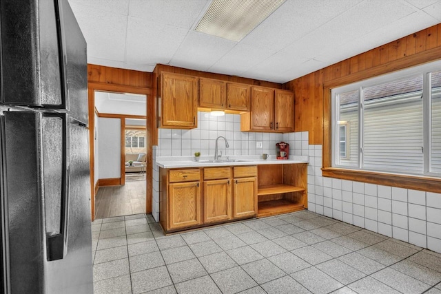 kitchen with sink, black fridge, and decorative backsplash