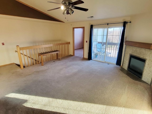 unfurnished living room with vaulted ceiling, a tile fireplace, ceiling fan, and carpet