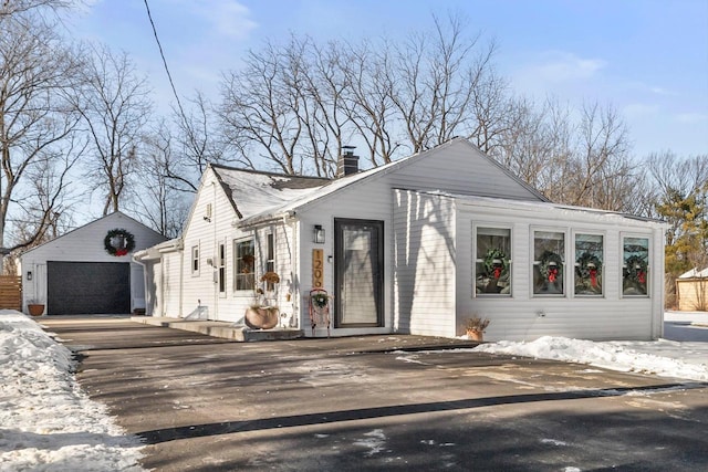 view of front of property featuring a garage and an outdoor structure