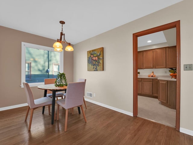 dining space featuring light hardwood / wood-style flooring and a chandelier