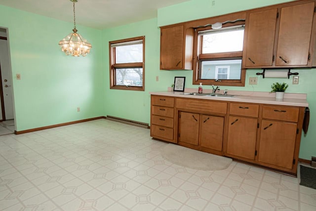 kitchen with a wealth of natural light, an inviting chandelier, pendant lighting, and sink