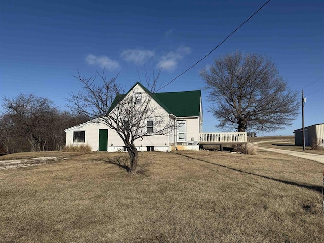 view of home's exterior with a yard and a wooden deck