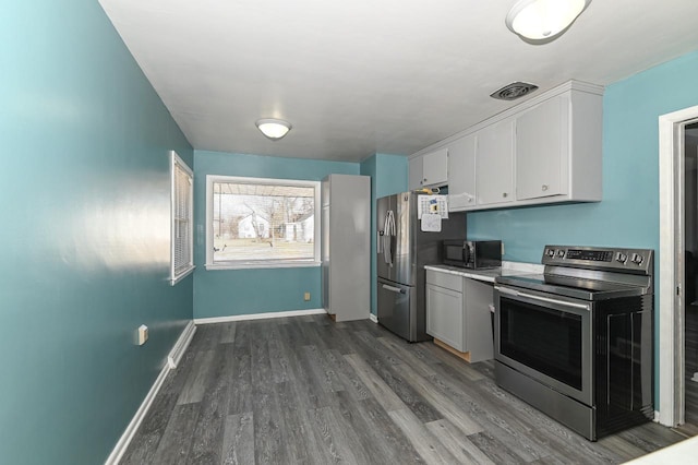 kitchen with stainless steel appliances, white cabinets, and dark hardwood / wood-style flooring