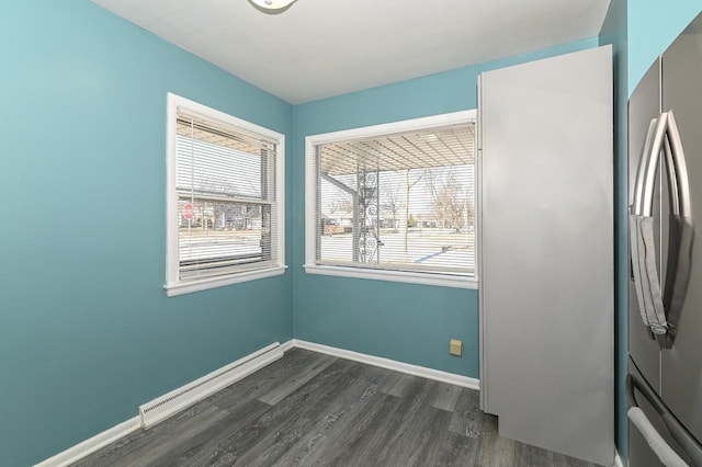 interior space featuring a baseboard heating unit and dark hardwood / wood-style floors