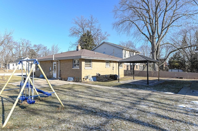 back of house with a gazebo and a playground