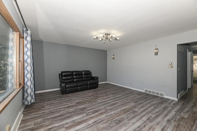 unfurnished room featuring an inviting chandelier and dark hardwood / wood-style floors