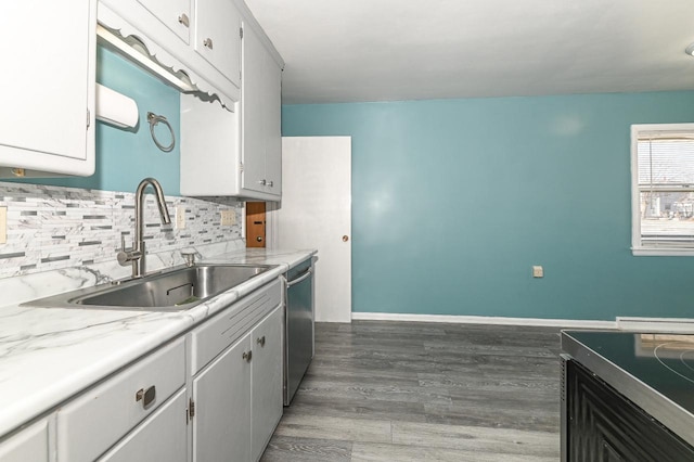 kitchen featuring sink, stainless steel dishwasher, white cabinetry, and tasteful backsplash