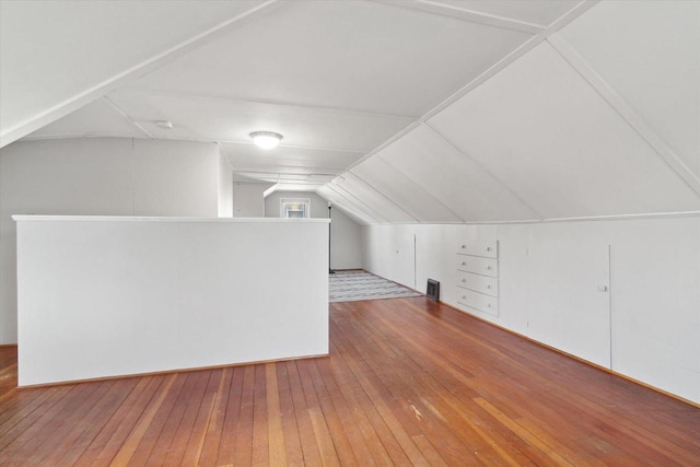 bonus room featuring light wood-type flooring and vaulted ceiling