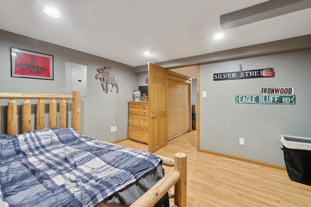 bedroom with electric panel and hardwood / wood-style flooring