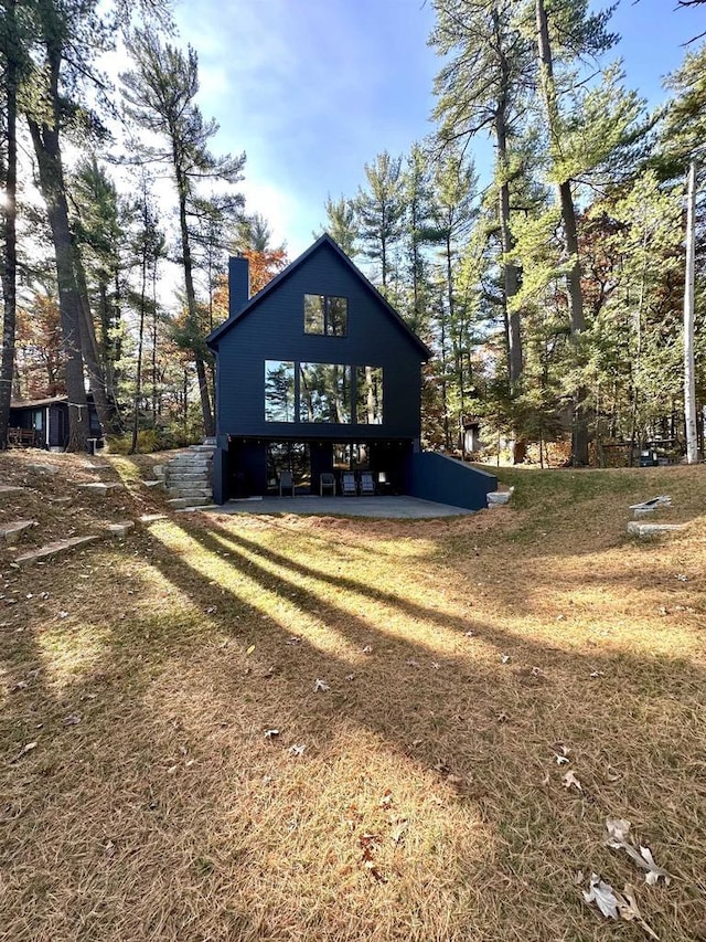 rear view of house featuring a lawn