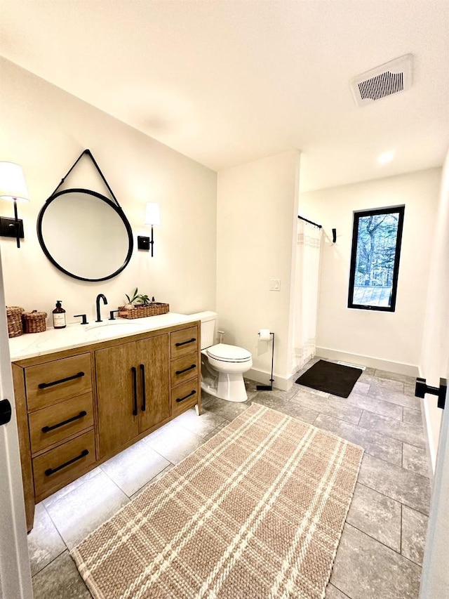 bathroom with walk in shower, vanity, and toilet