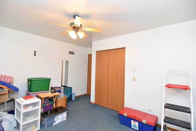 rec room with ceiling fan and dark carpet