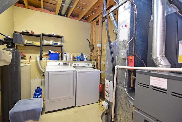 washroom featuring washing machine and dryer, water heater, and heating unit