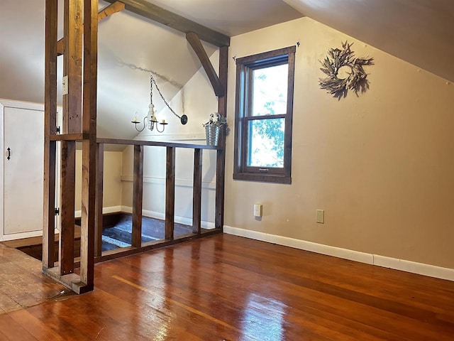 bonus room featuring dark wood-type flooring, vaulted ceiling, and a chandelier