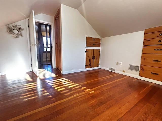 additional living space with dark wood-type flooring and vaulted ceiling