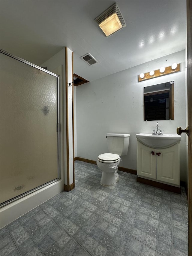 bathroom featuring toilet, vanity, and a shower with shower door