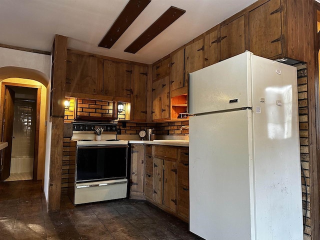 kitchen with sink, white appliances, and wood walls