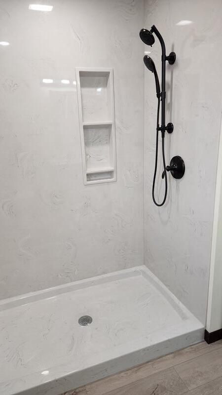 bathroom featuring hardwood / wood-style flooring and tiled shower