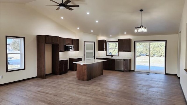 kitchen with appliances with stainless steel finishes, pendant lighting, a center island, and wood-type flooring