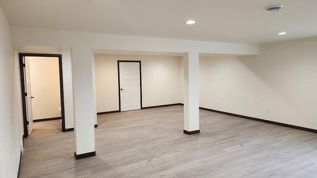 basement with light hardwood / wood-style flooring