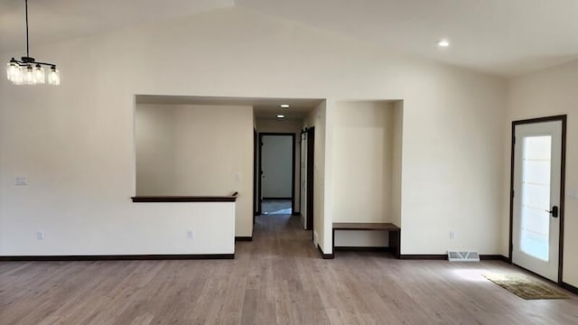 unfurnished room featuring lofted ceiling and hardwood / wood-style floors