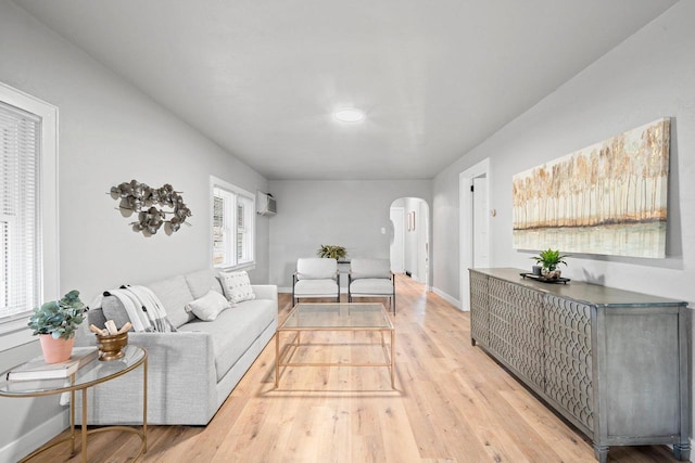 living room featuring light hardwood / wood-style floors and an AC wall unit