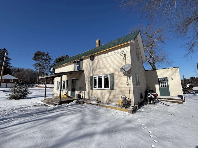 view of snow covered rear of property