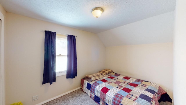 carpeted bedroom featuring lofted ceiling and a textured ceiling