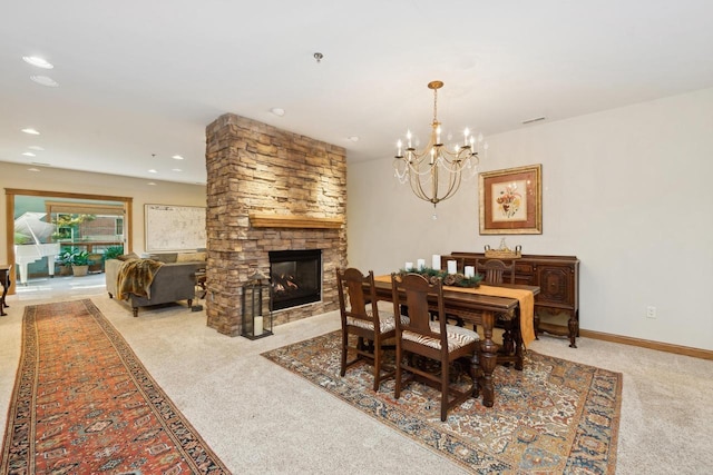 dining room featuring a fireplace, a chandelier, and light carpet