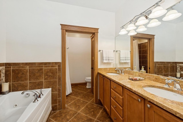 bathroom featuring toilet, tile patterned flooring, vanity, and a tub to relax in