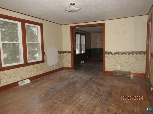 unfurnished room featuring ornamental molding and dark hardwood / wood-style flooring