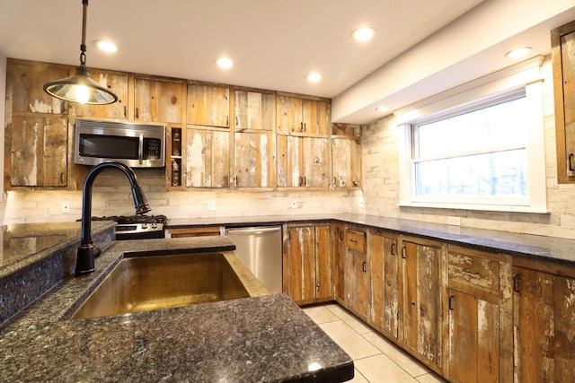 kitchen with stainless steel appliances, sink, light tile patterned floors, decorative backsplash, and hanging light fixtures