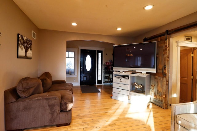 living room with light hardwood / wood-style floors and a barn door