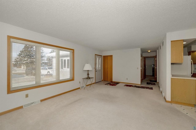 unfurnished living room with a textured ceiling and light carpet