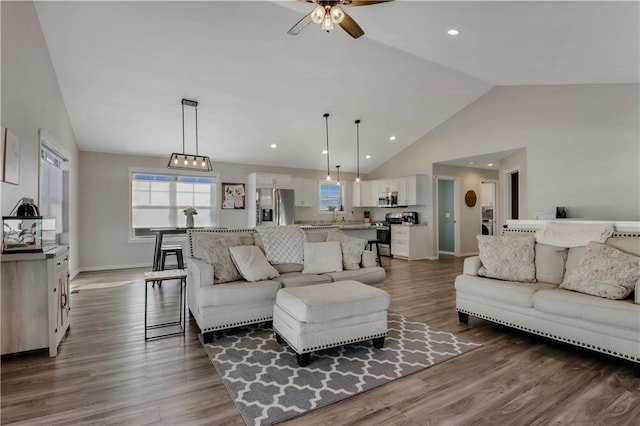 living room featuring ceiling fan, high vaulted ceiling, and hardwood / wood-style flooring