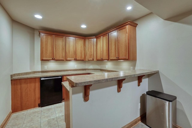 kitchen with black dishwasher, light tile patterned floors, a kitchen bar, and kitchen peninsula