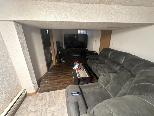 living room featuring a baseboard heating unit, hardwood / wood-style flooring, and a textured ceiling