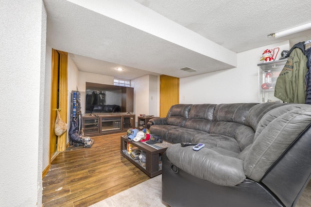 living room with wood-type flooring and a textured ceiling