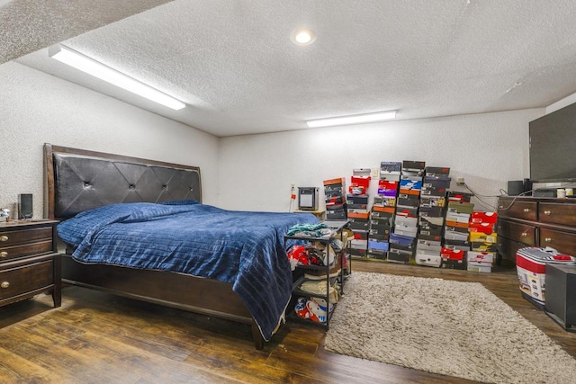 bedroom with dark wood-type flooring and a textured ceiling