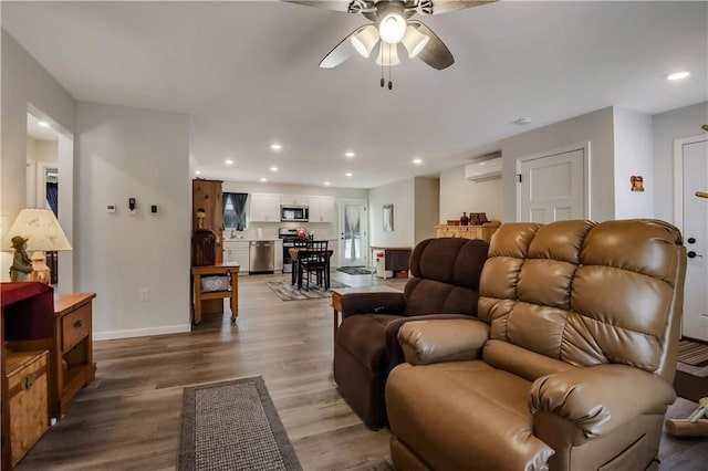 living room with an AC wall unit, ceiling fan, and hardwood / wood-style floors